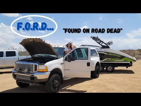 White Ford truck with the hood up towing a boat. F.O.R.D. Found On Road Dead.