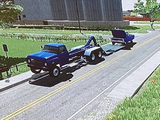 Blue Ford tow truck hauling a blue Ford pickup with its hood up